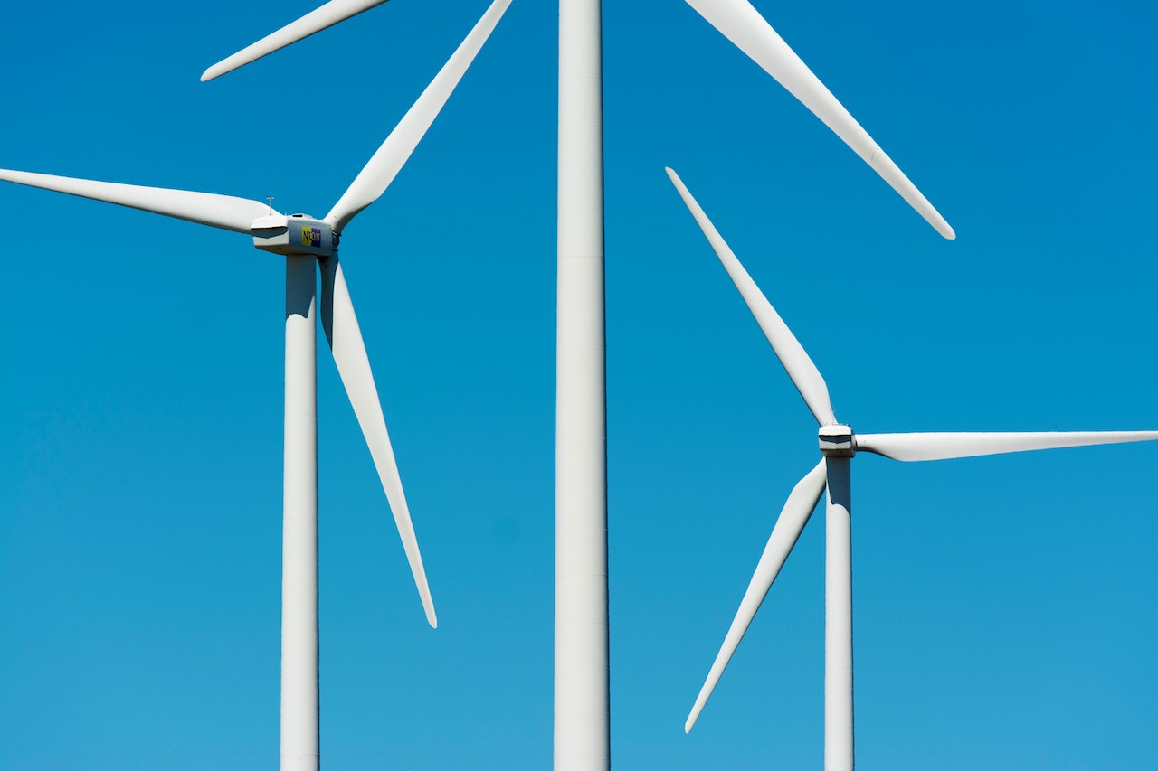 White Wind Turbines Under the Clear Blue Sky