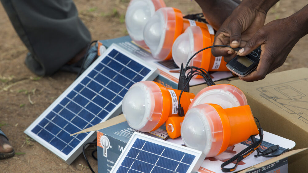 Solar lights being used in a Malawian flood refugee camp. - stock photo In mid January 2015, a three day period of excessive rain brought unprecedneted floods to the small poor African country of Malawi. It displaced nearly quarter of a million people, devastated 64,000 hectares of alnd, and killed several hundred people. This shot shows a solar lamps being charged in the refugee camp of Chiteskesa refugee camp, near Mulanje.