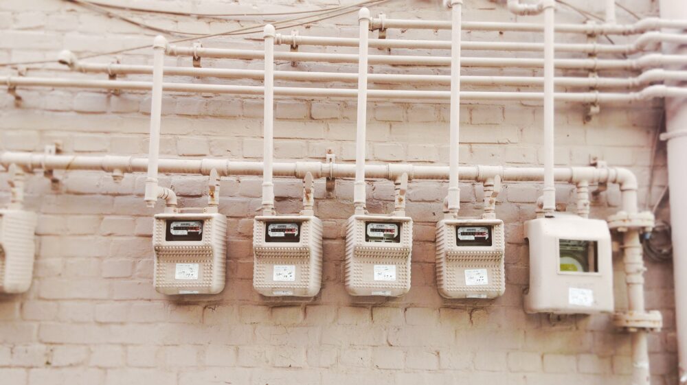 Monochrome beige power meters are lined up against an exterior brick wall in Soeul, Korea.