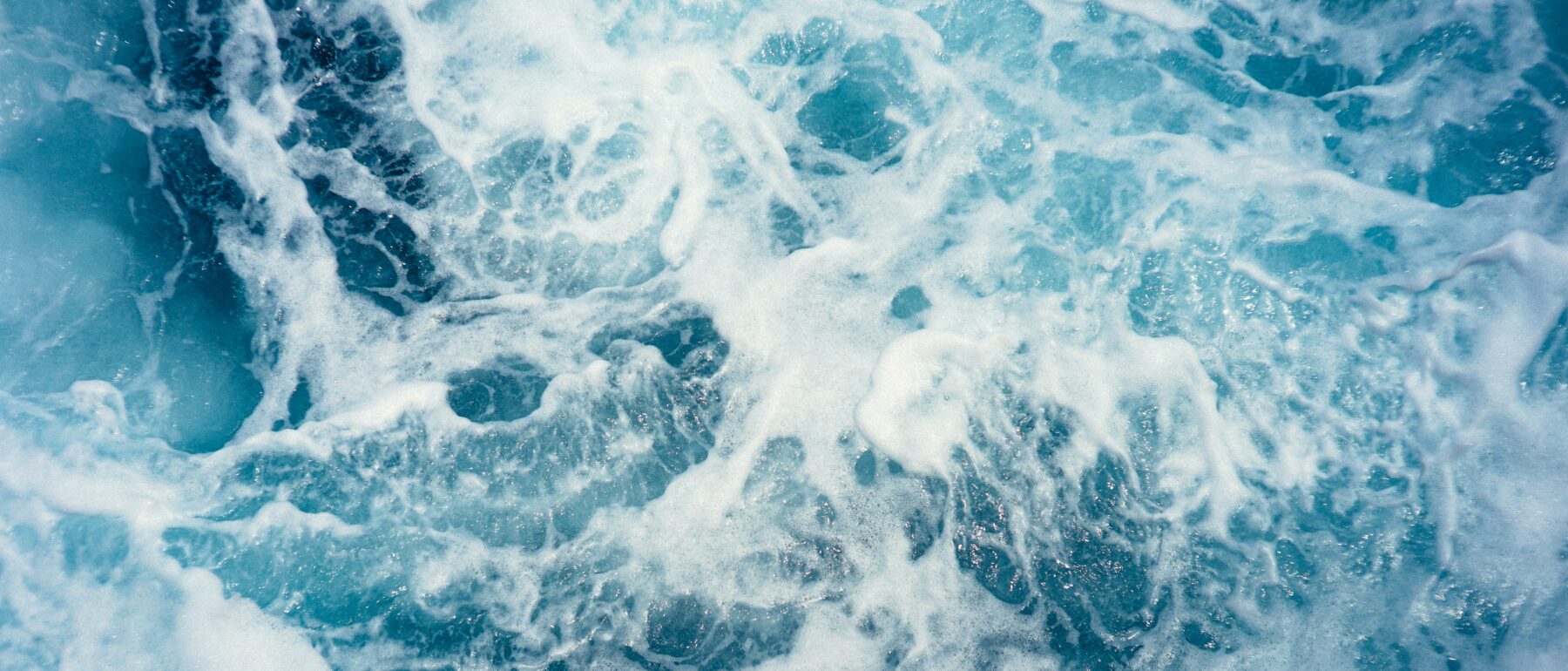 aerial view of blue crashing waves in the sea