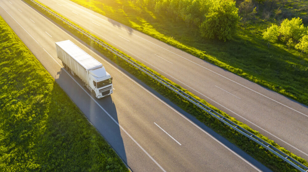 Aerial view of truck driving on asphalt road.