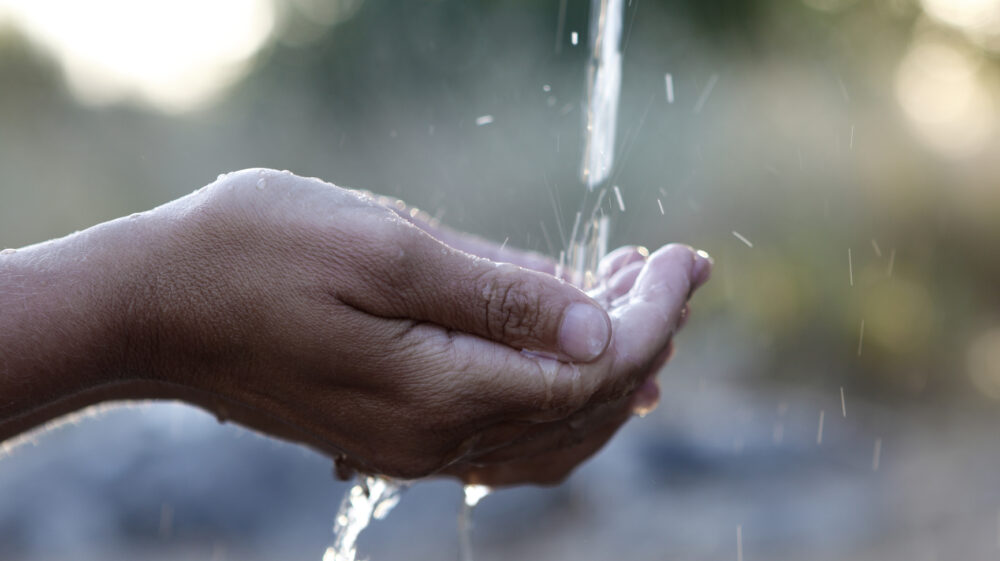 Splashing water on women's hand.
