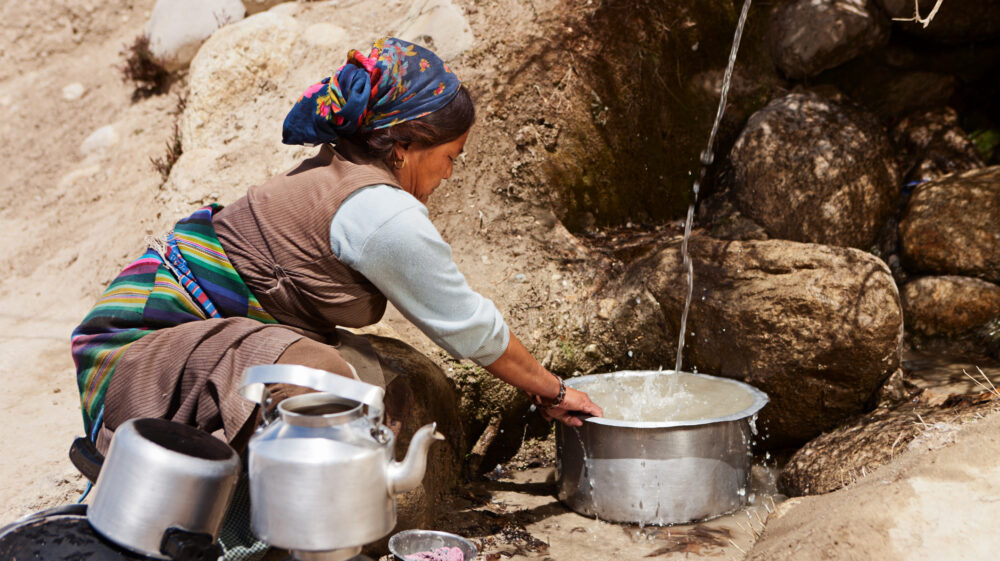Tibetan woman washing dishes near Lo Manthan in Mustang. Mustang