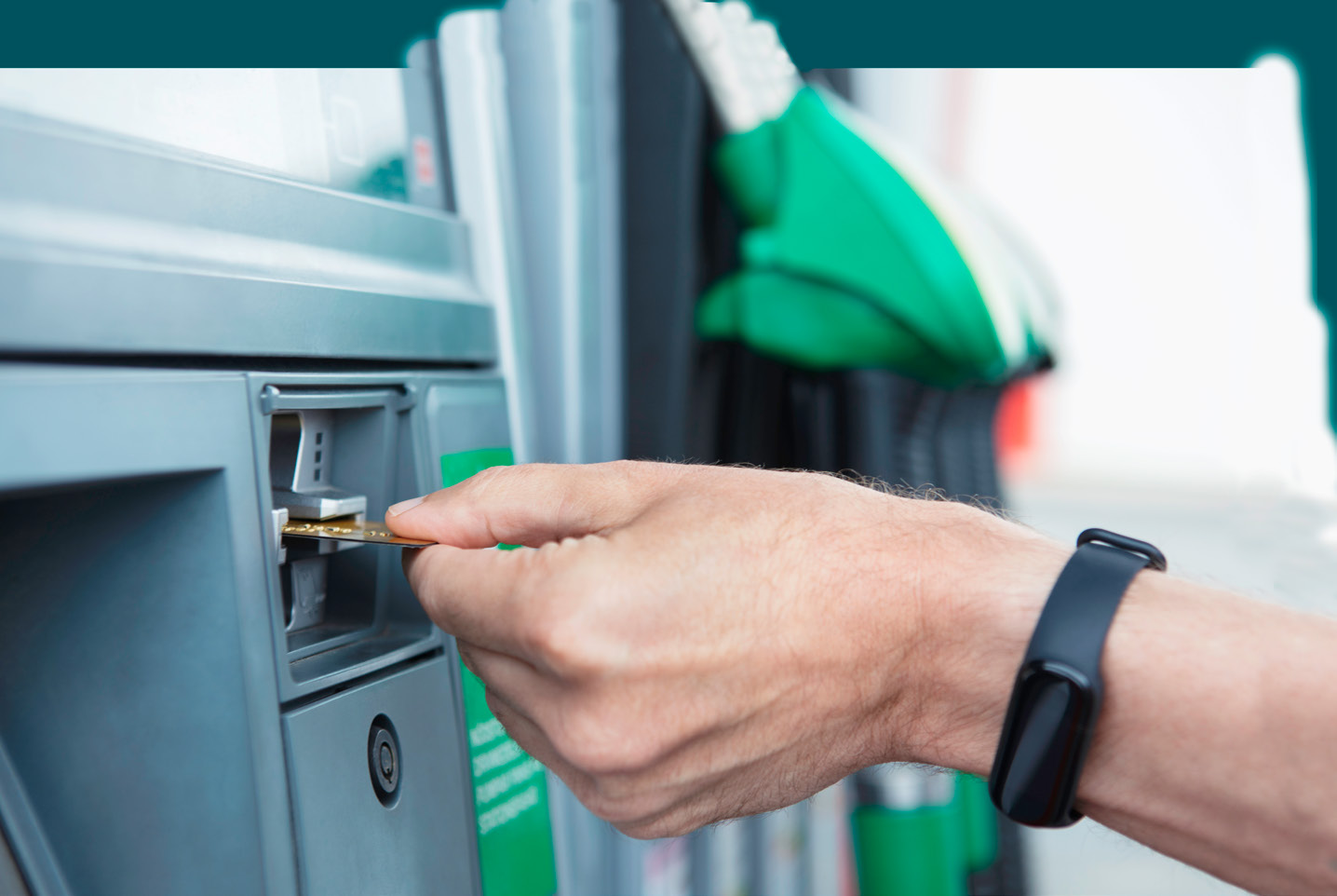 A man's hand inserting a credit card into a gas pump in Sweden.