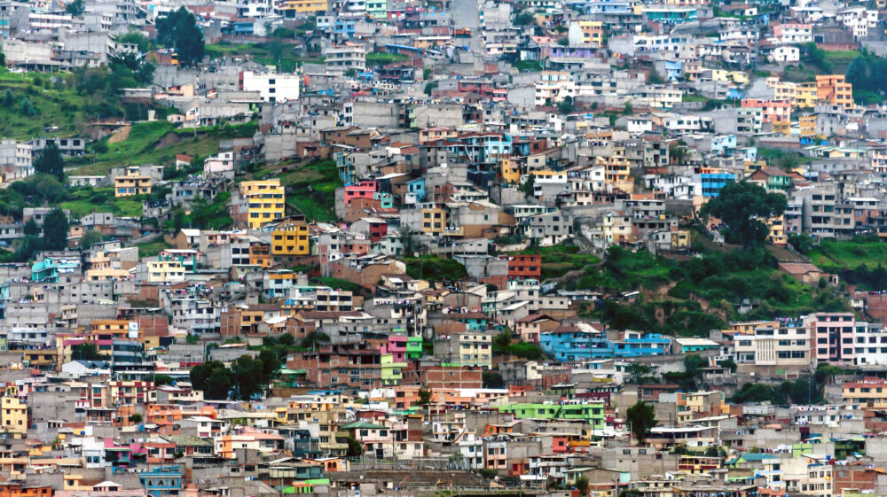 Landscape photo of densely packed, colourful buildings on a hillside in Quito, Ecuador.