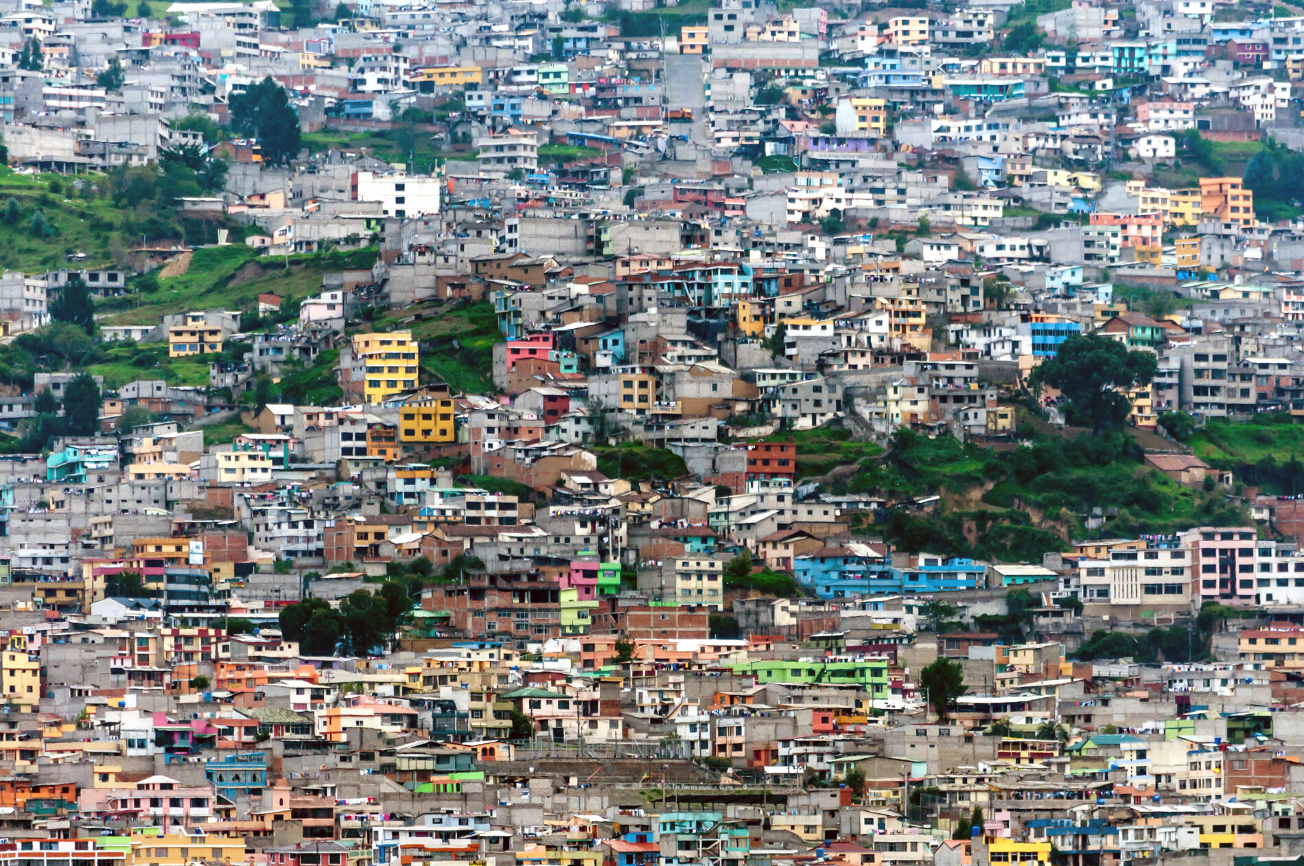 Landscape photo of densely packed, colourful buildings on a hillside in Quito, Ecuador.