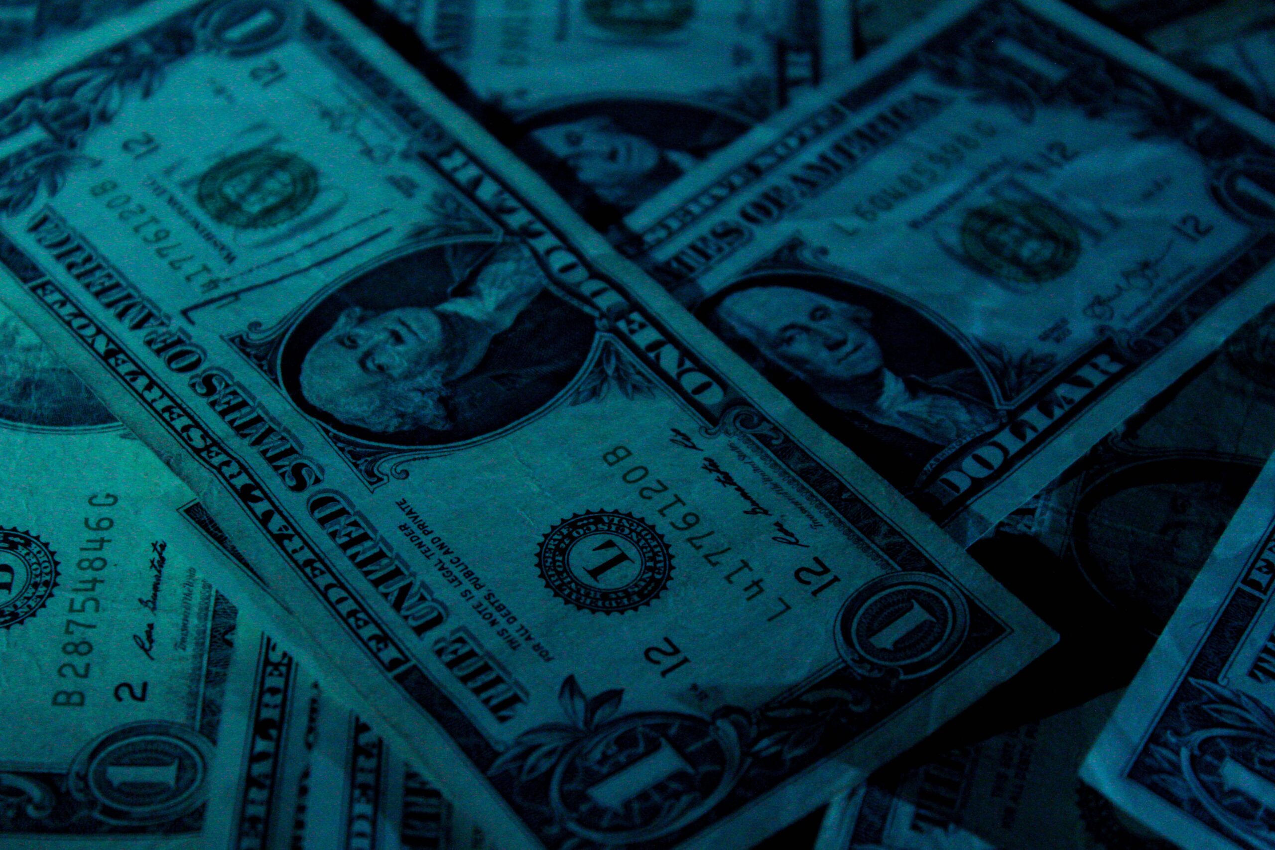 Dark image of US dollar bills.