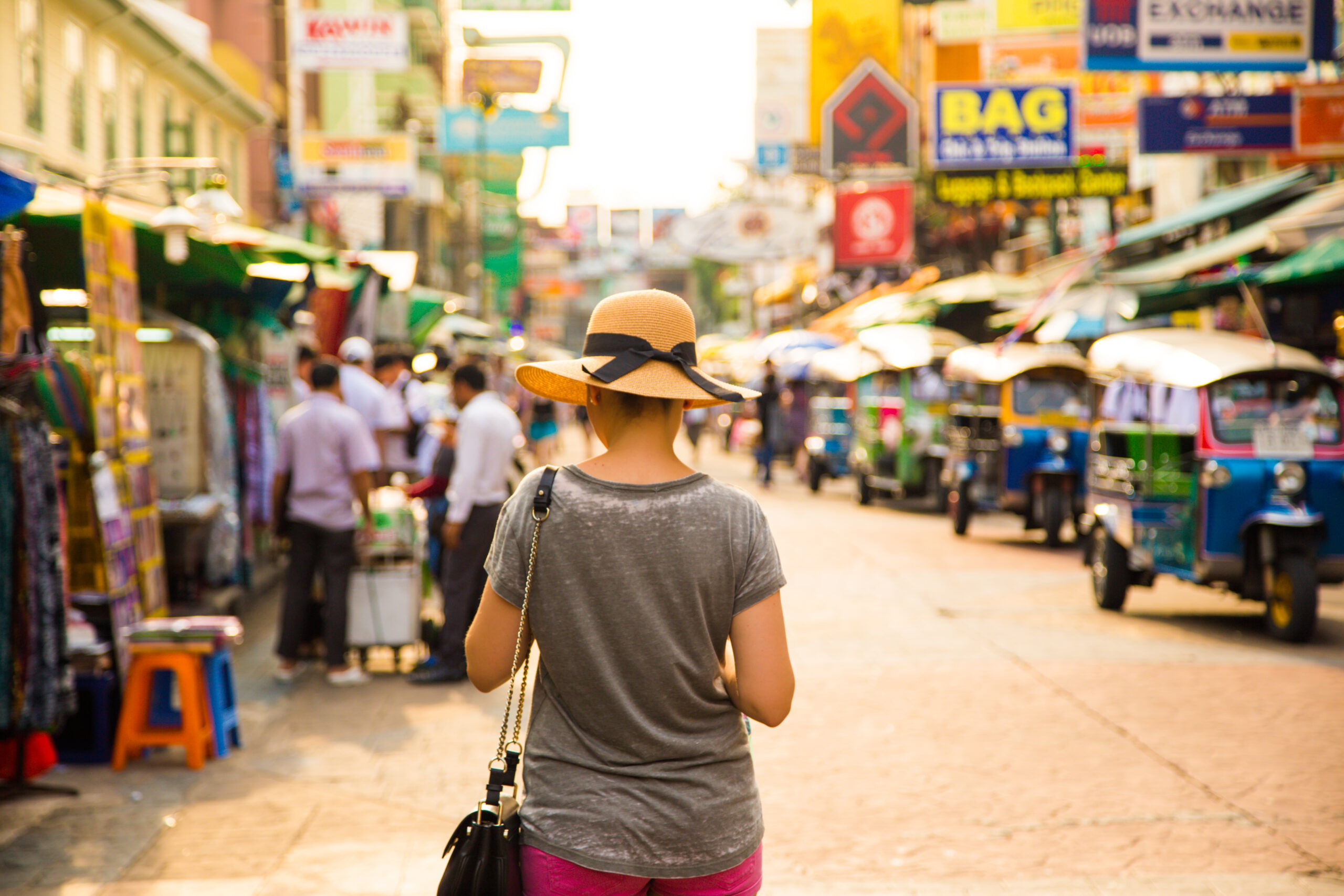 A women with hat in a busy street in Bangkok, Thailand.