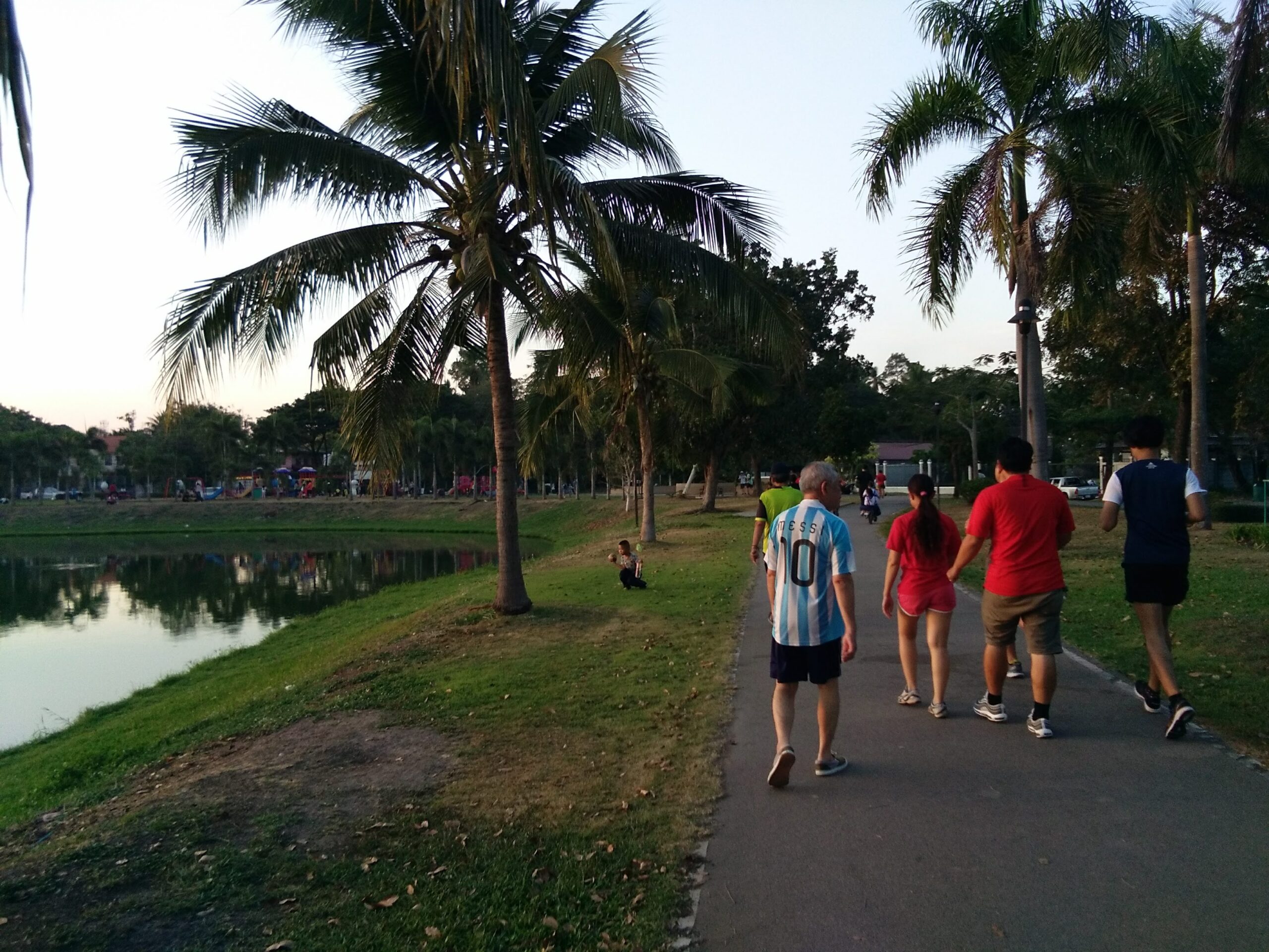 Group of people walking through greenspace in Udon Thani.