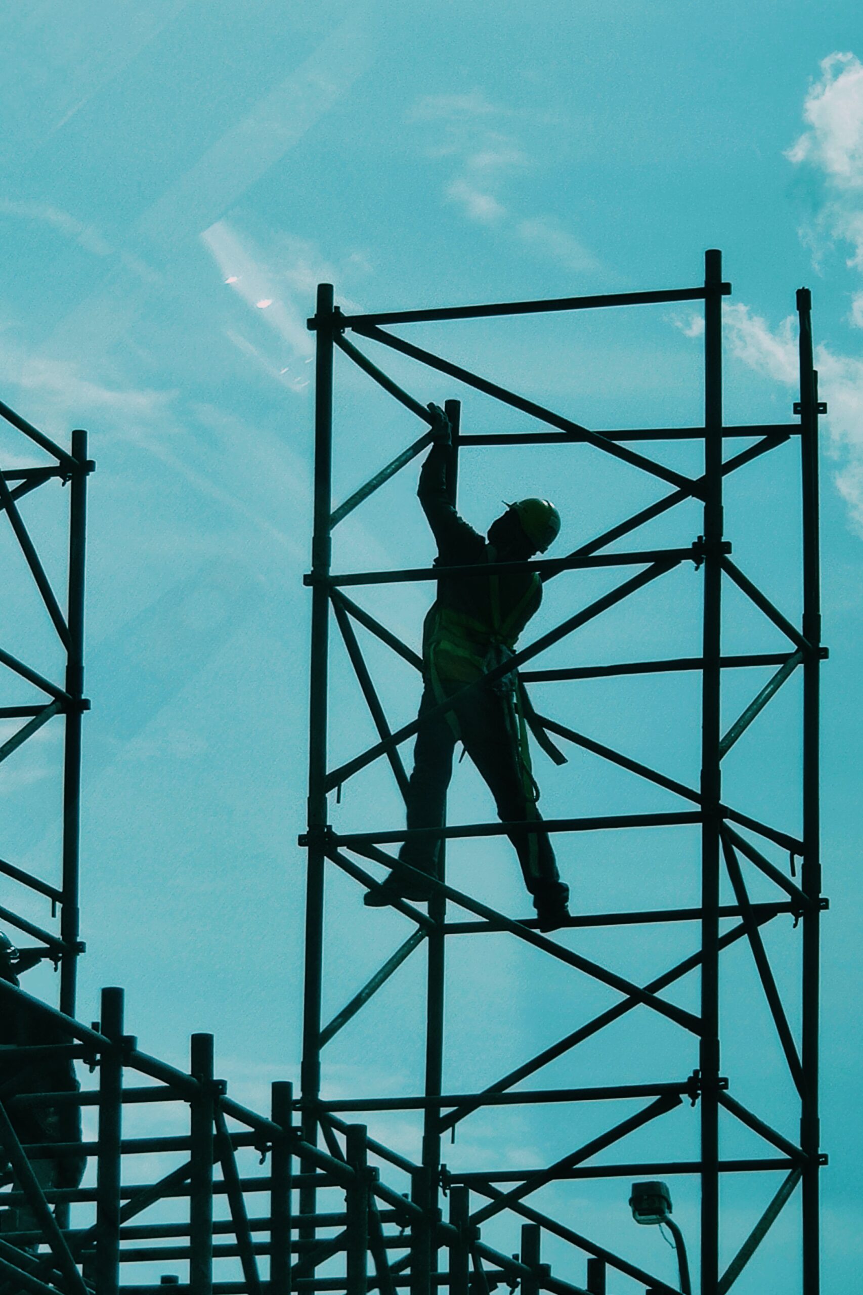 construction worker on a metal bar structure against blue sky
