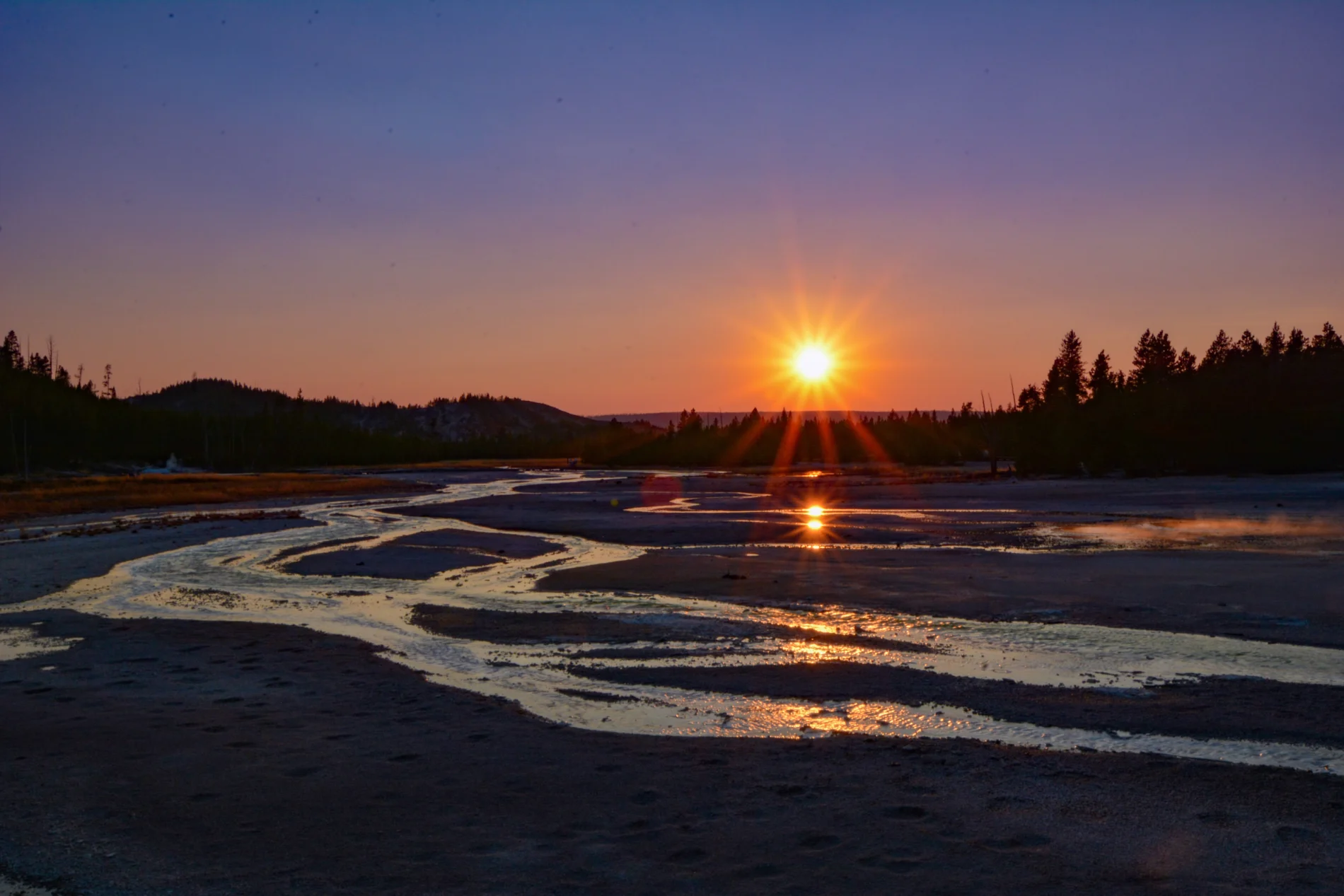 River meanders across a flat surface at sunset