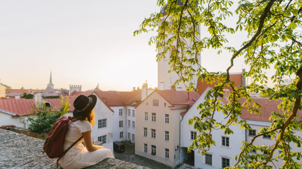 Young woman sitting and looking at Tallinn in the morning.