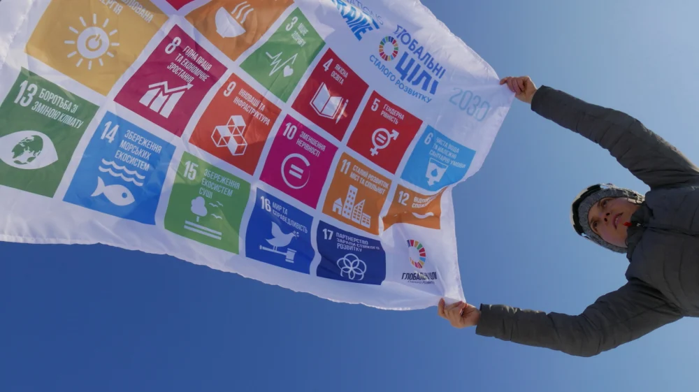 Woman holding flag displaying the Global Goals.