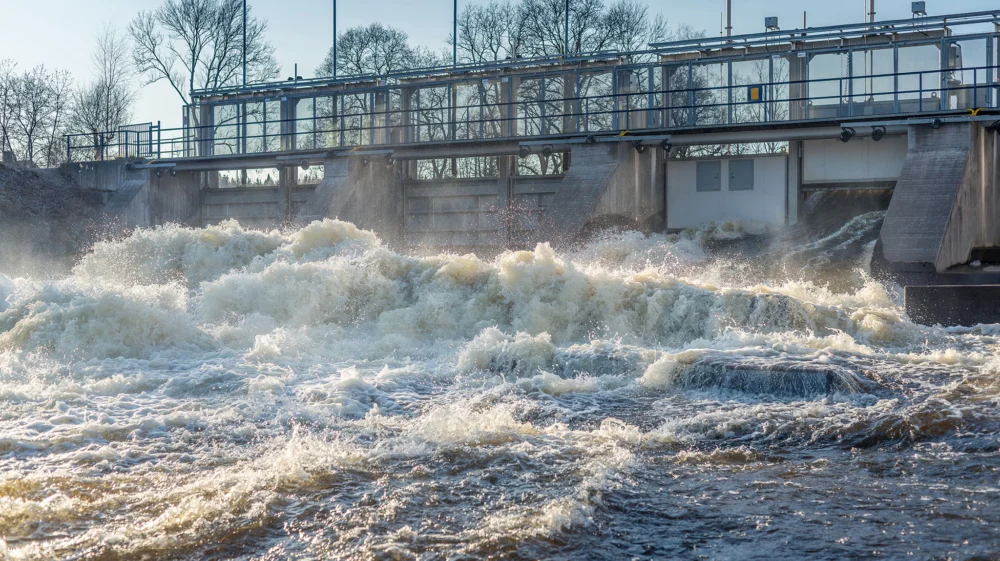 Hydropower dam with water flowing at high levels in spring, in Sweden