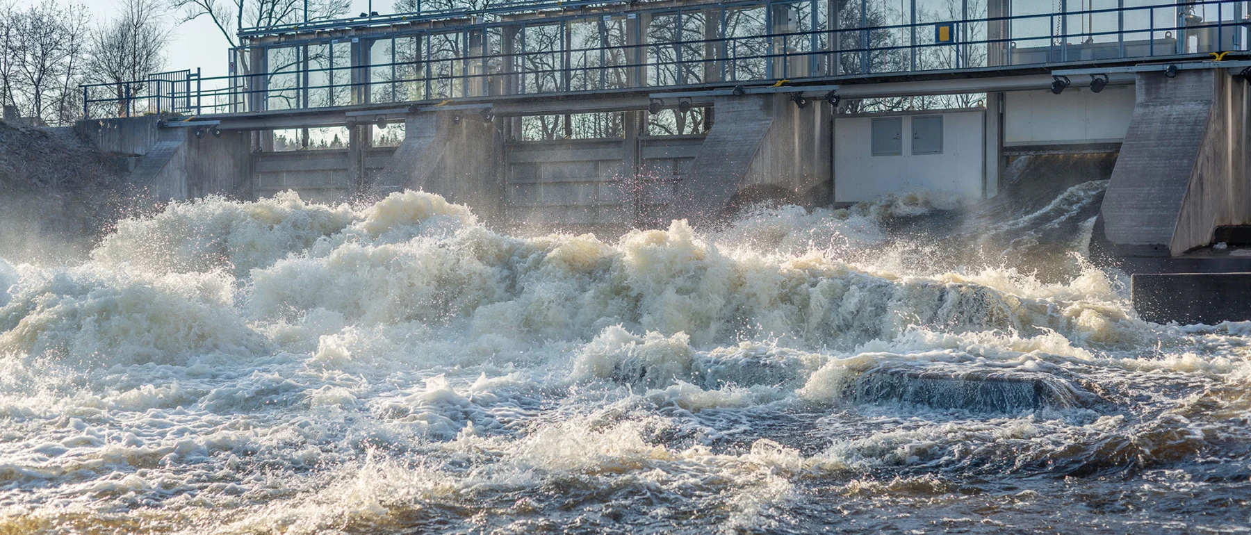 Hydropower dam with water flowing at high levels in spring, in Sweden