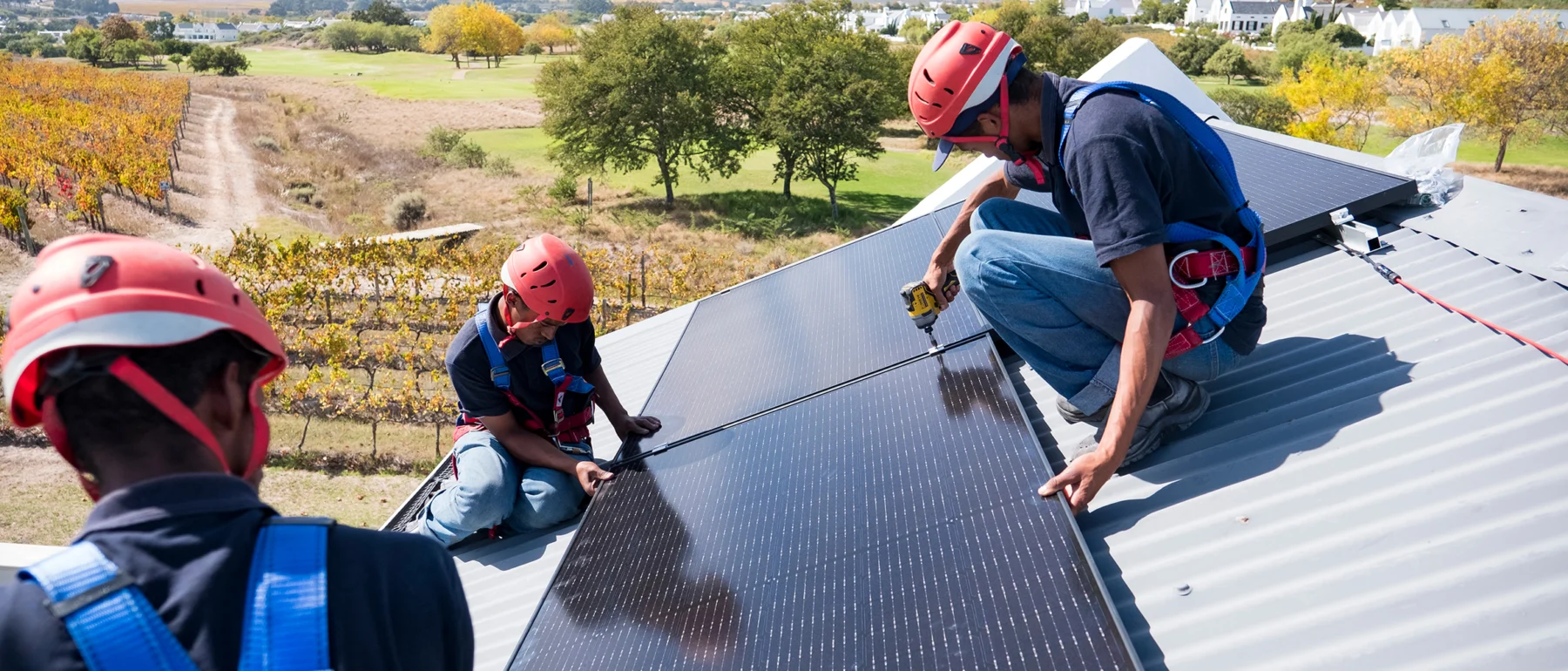 Workers install solar panels on a house in Cape Town, South Africa.