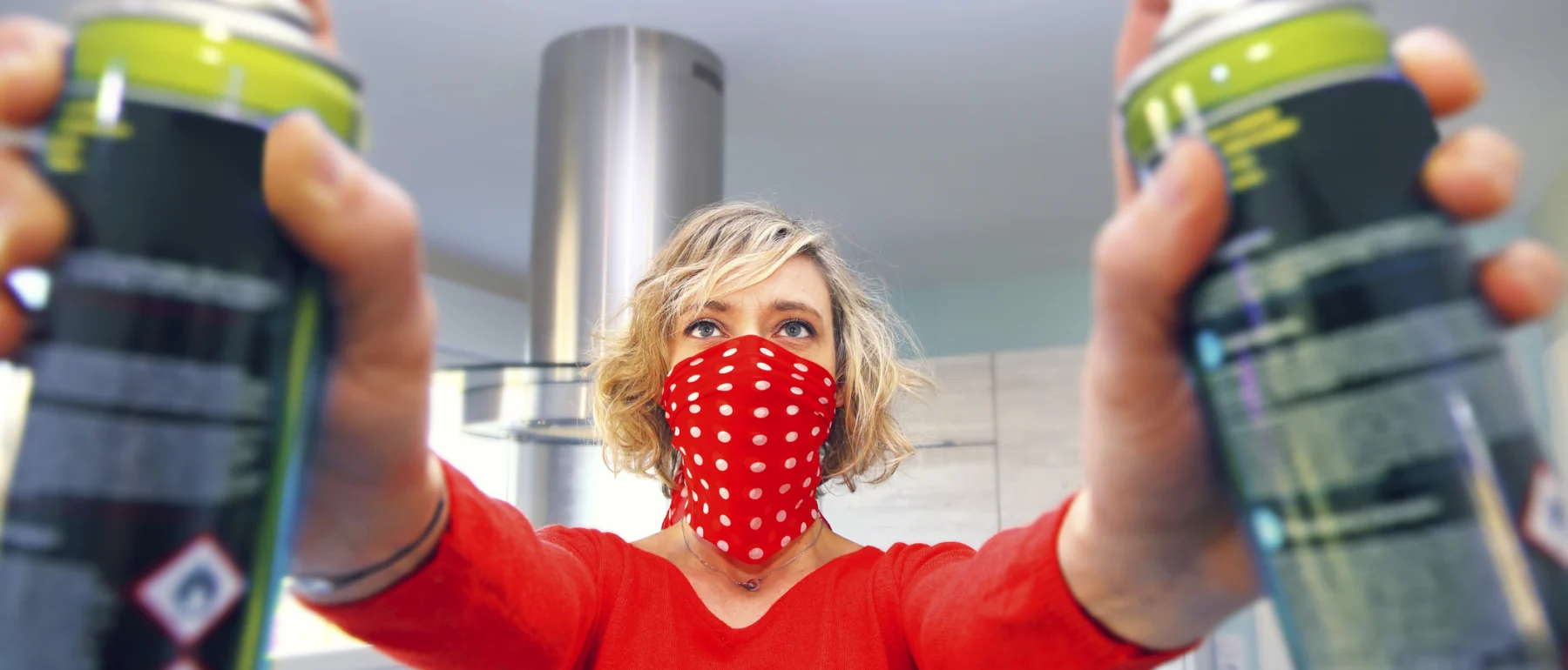 Young woman at home using air spray - stock photo
