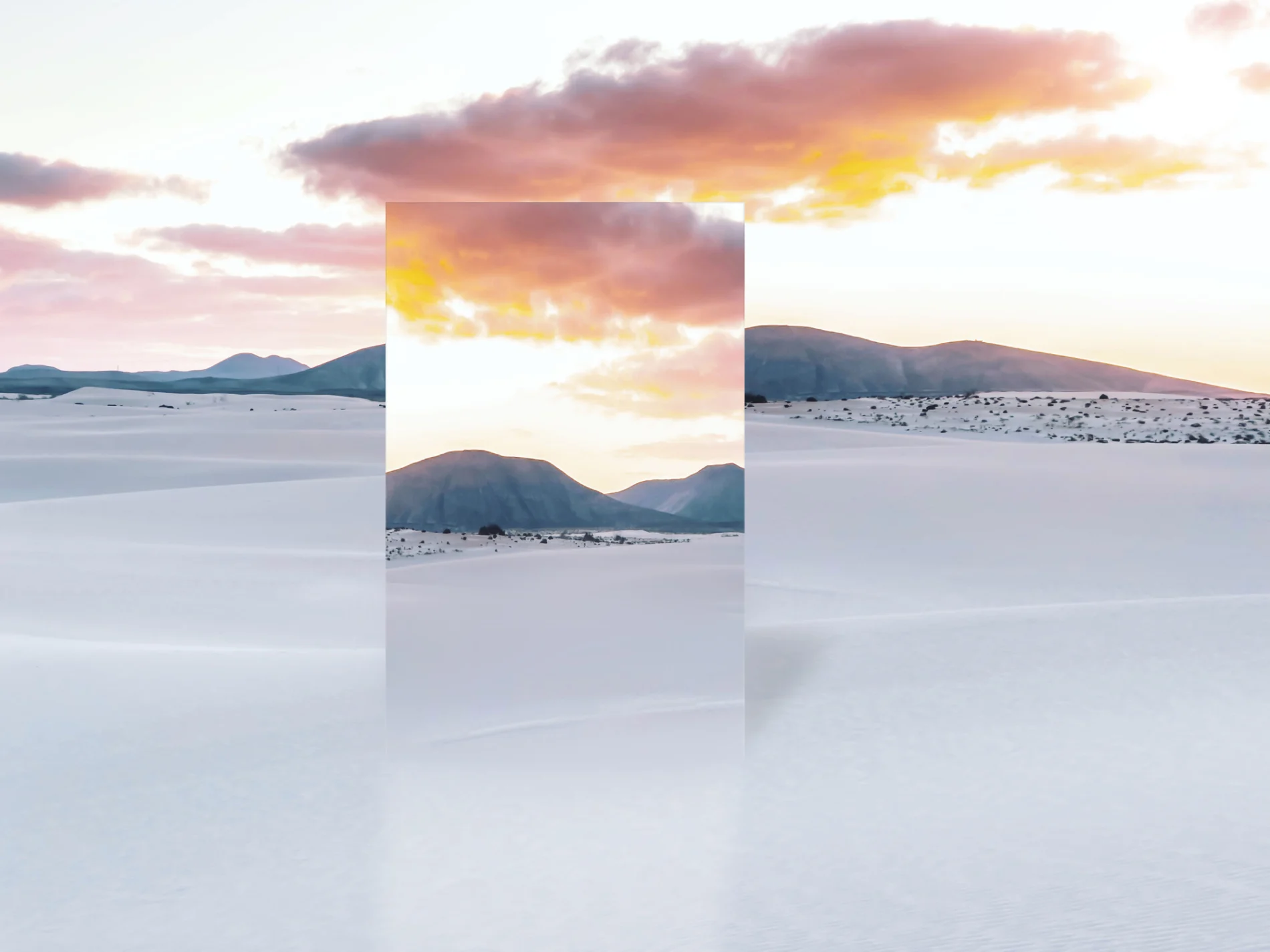 Mirror reflecting desert dunes with dramatic sunset sky.
