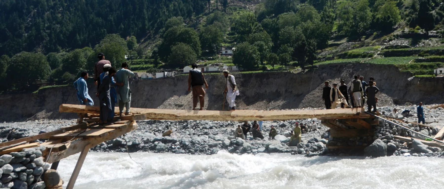 People cross a makeshift bridge after floods hit the Pakistan’s Khyber Pakhtunkhwa province in September 2022.