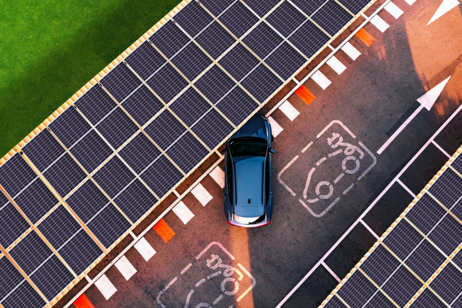 Aerial view of electric car parking in charging station with solar panels