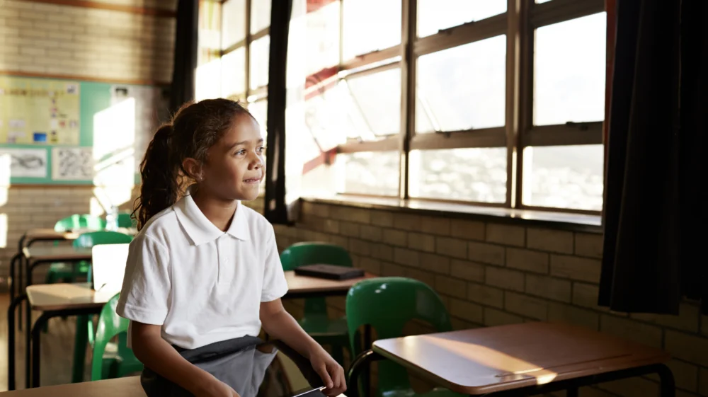 School child in classroom with tablet.