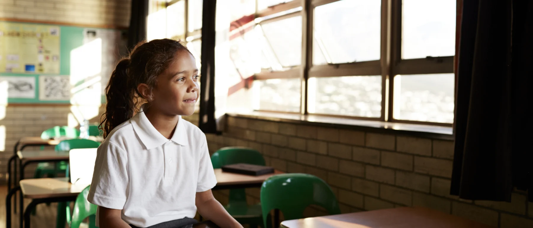 School child in classroom with tablet.