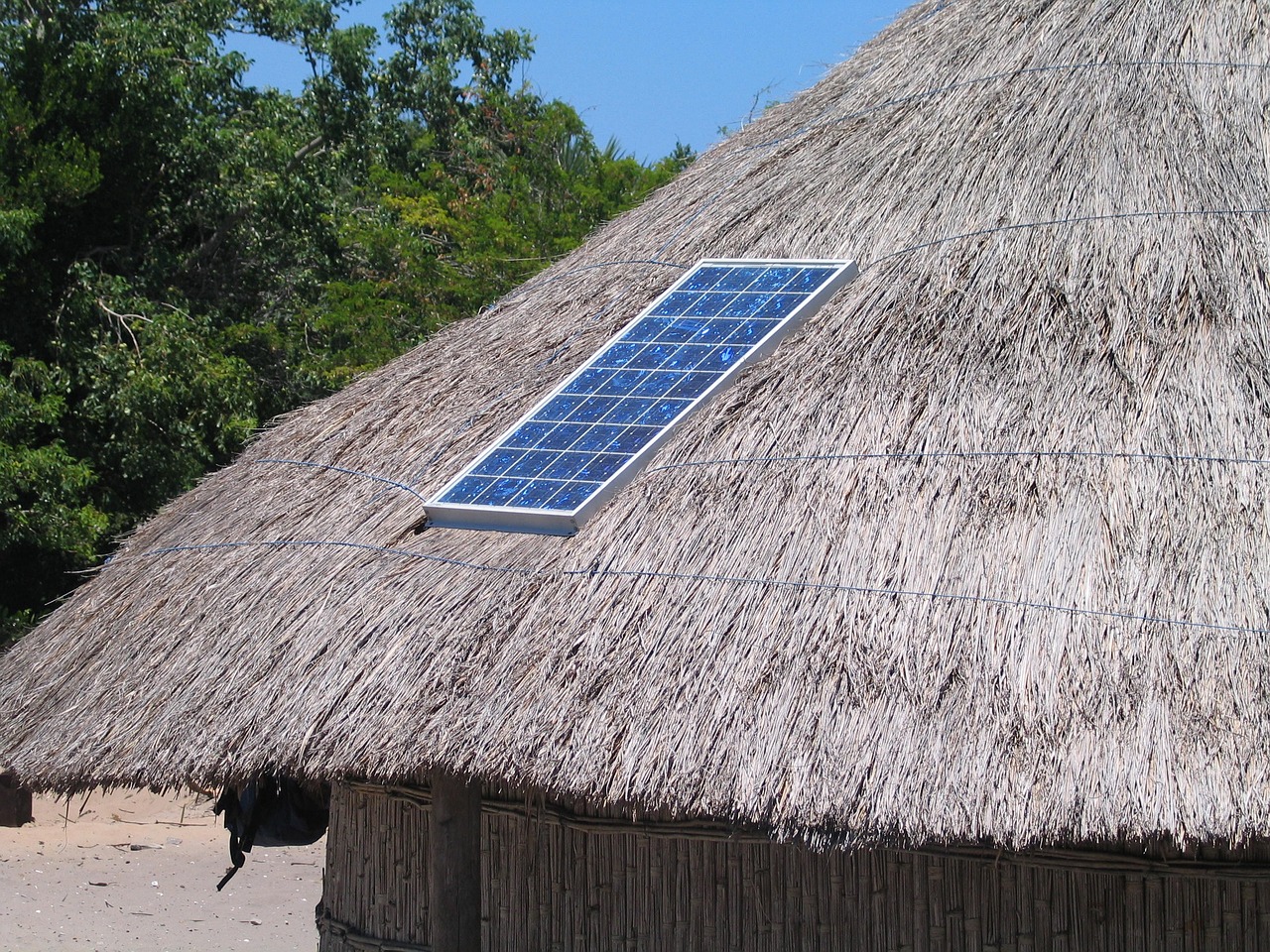 A solar panel on a traditional thatched house