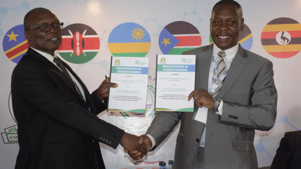 Sylvance Okoth and Philip Osano shaking hands after signing the agreement.