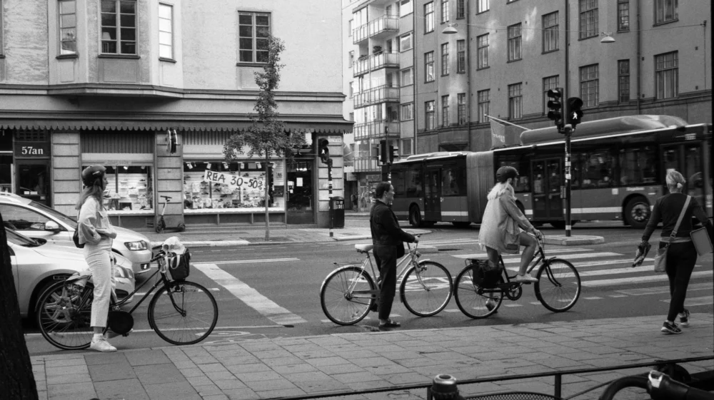 grayscale photo of people riding bicycle on street