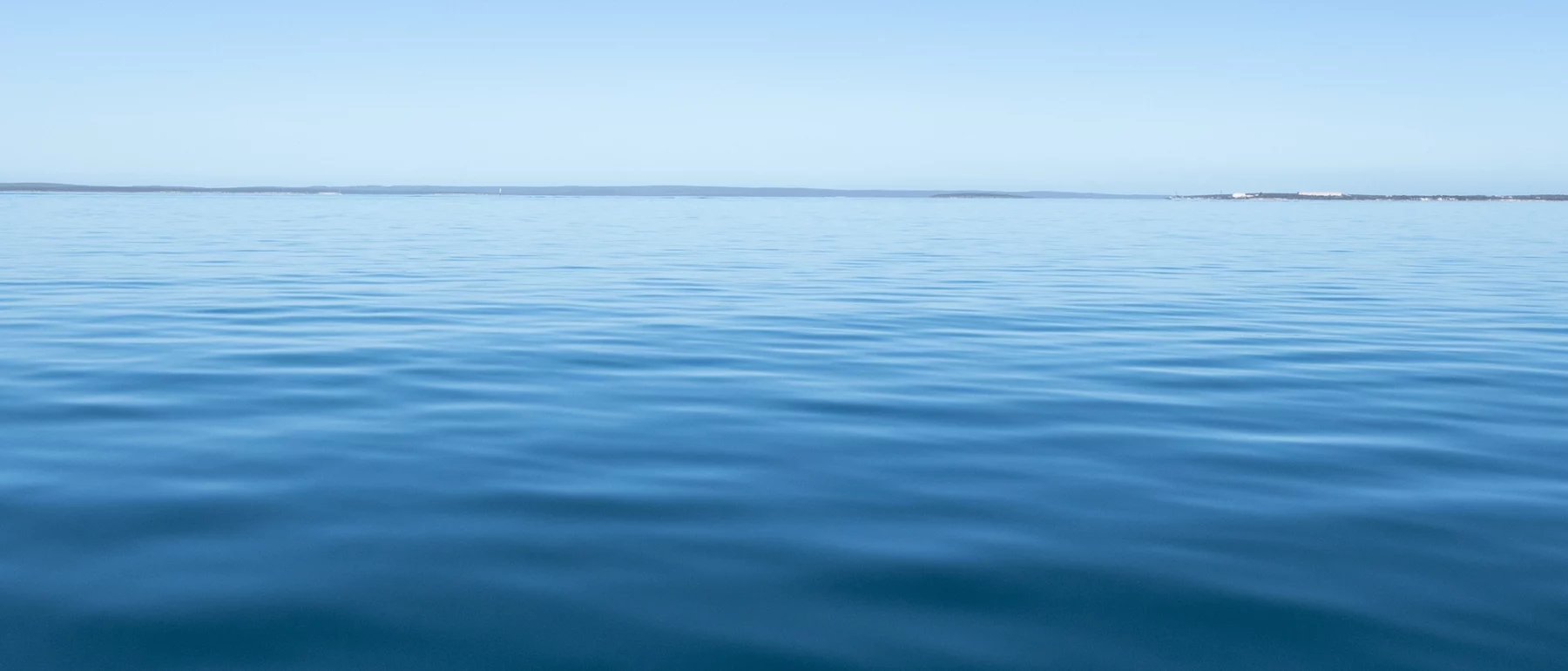 Calm blue ocean expanse under a clear sky.