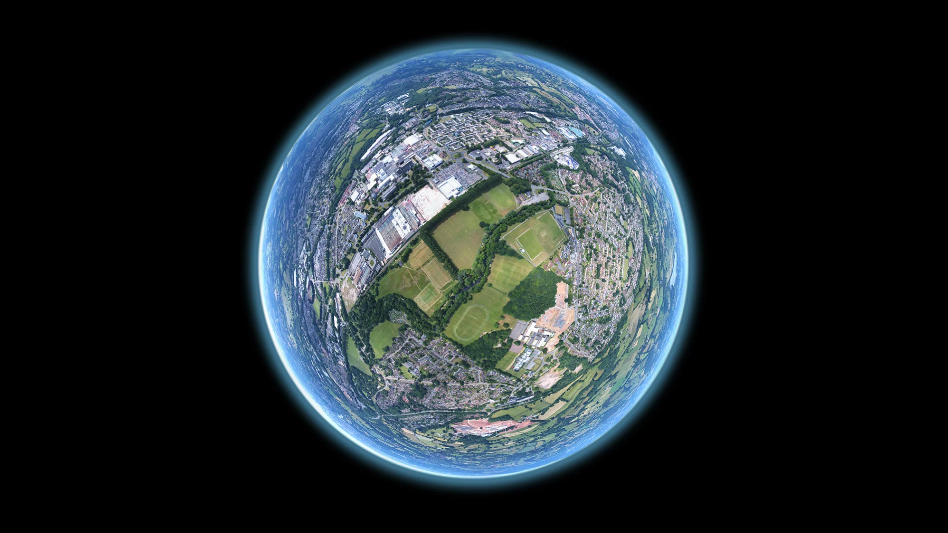 Fish-eye aerial shot of earth. Image sequence taken by drone above a community field in Wales.