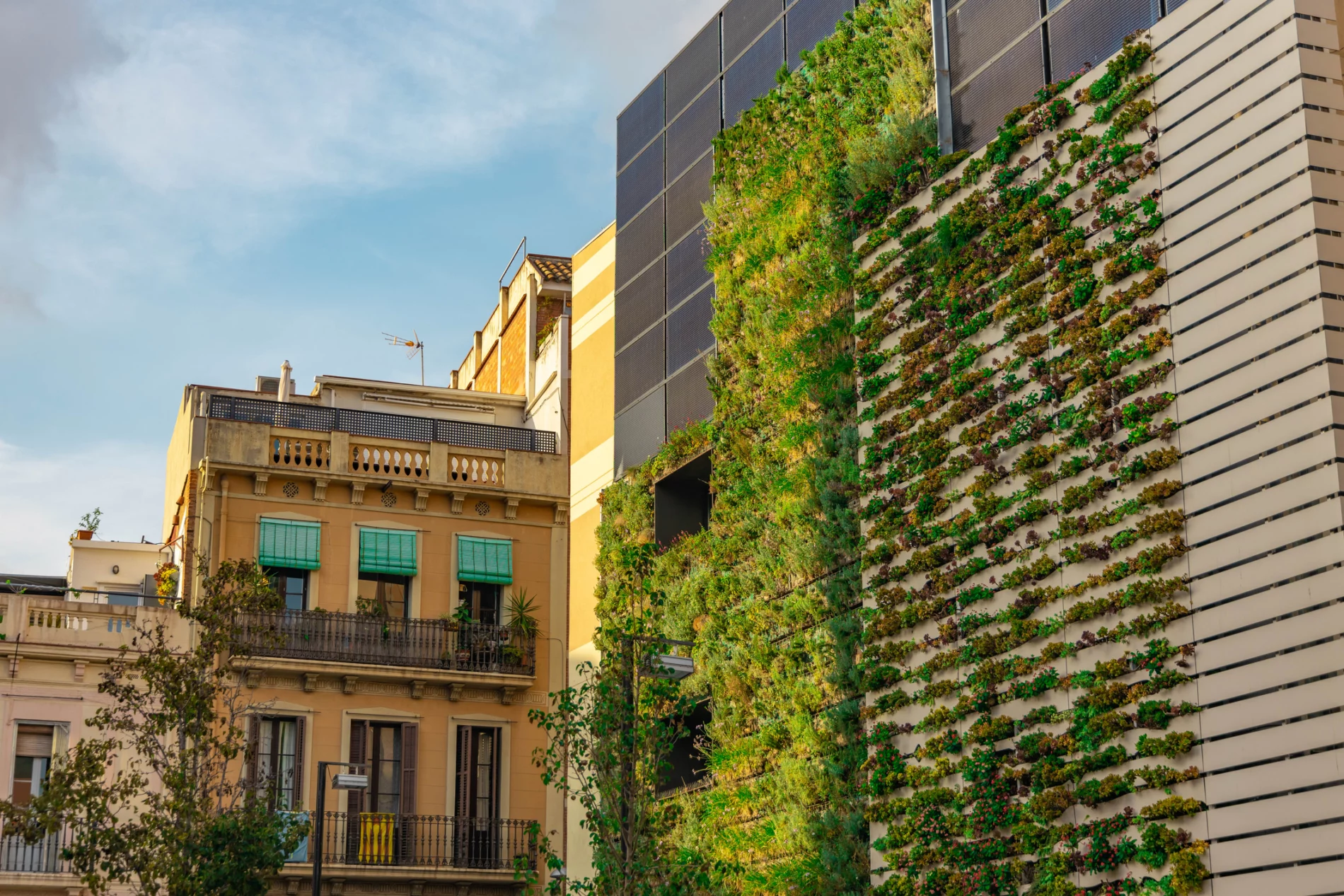 Sustainable building facade with a living wall and solar panels in the Barcelona city