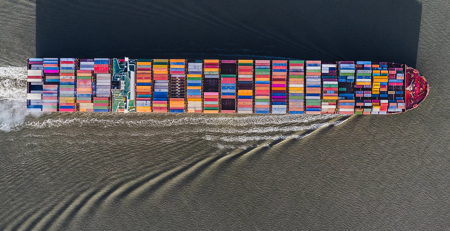 Aerial view of container ship casting a shadow shaped like a city skyline, Netherlands
