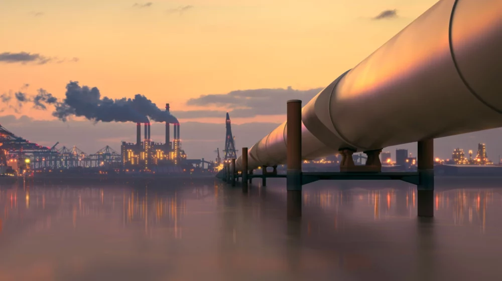Oil pipeline in industrial district with factories at dusk