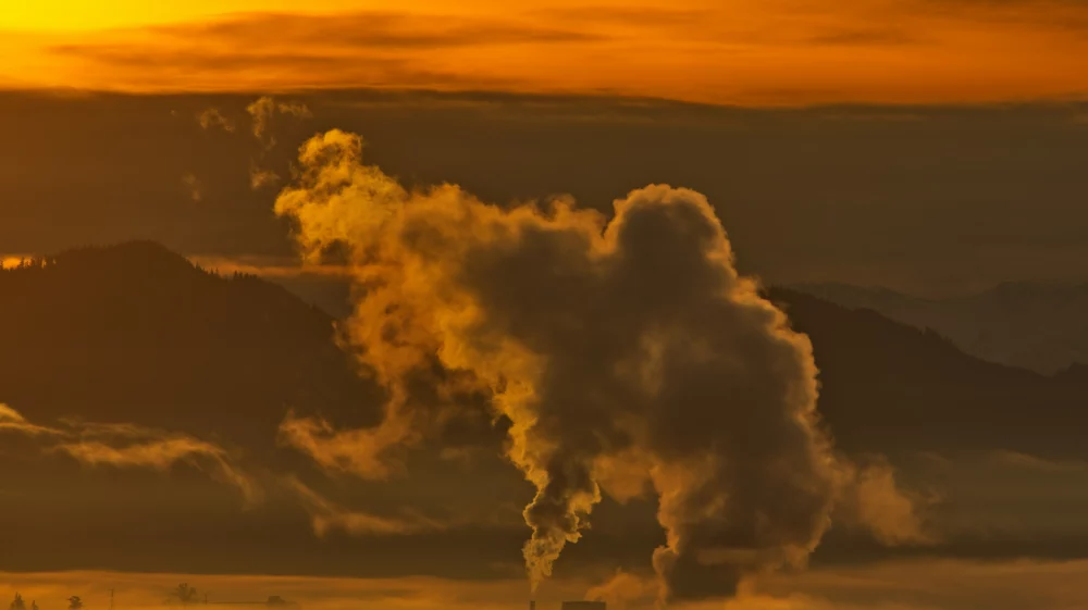 Large plume of smoke coming out of a pipe