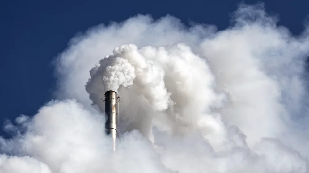 Industrial factory chimney emitting smoke and gas pollution into the atmosphere.