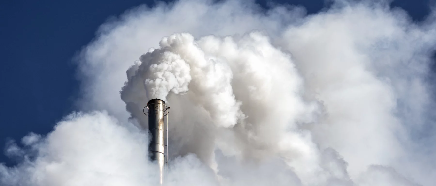 Industrial factory chimney emitting smoke and gas pollution into the atmosphere.