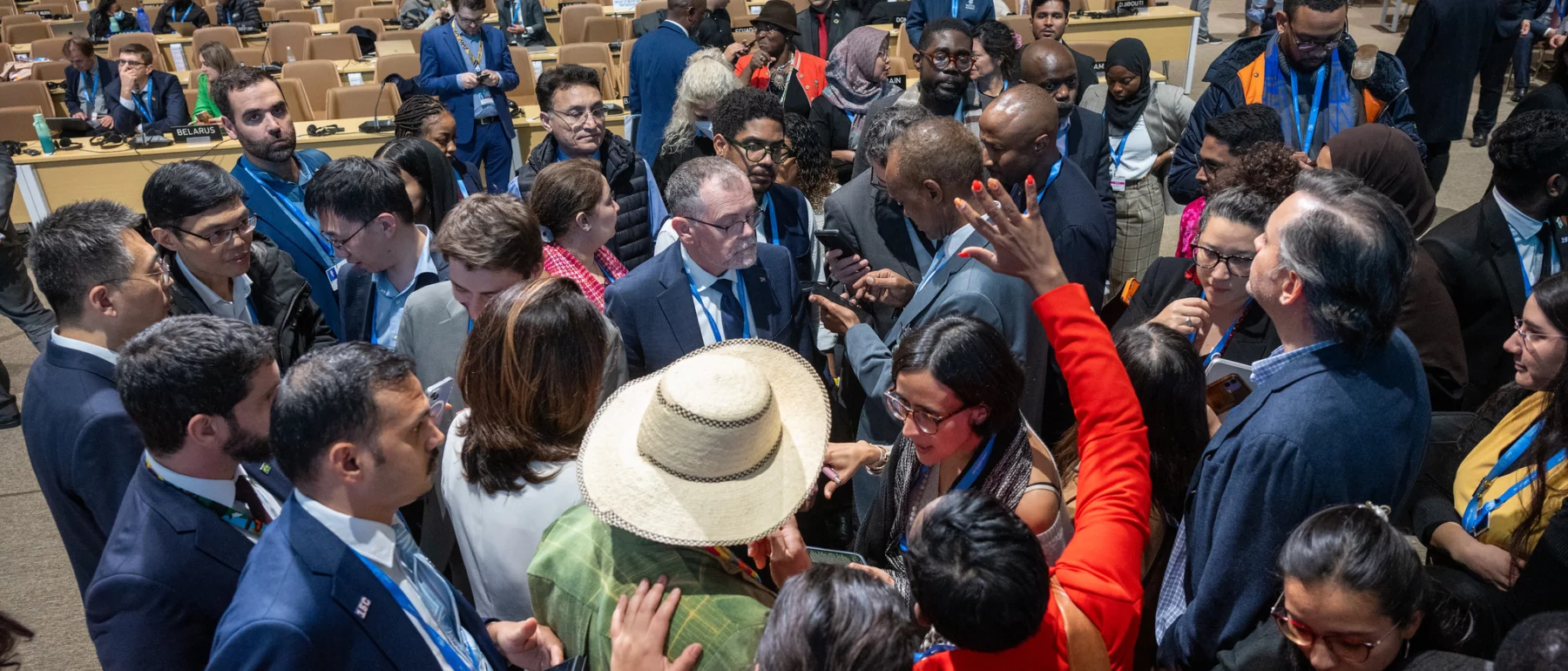 A diverse group of negotiators gathers in a heated discussion during the COP29 conference in Baku, Azerbaijan.