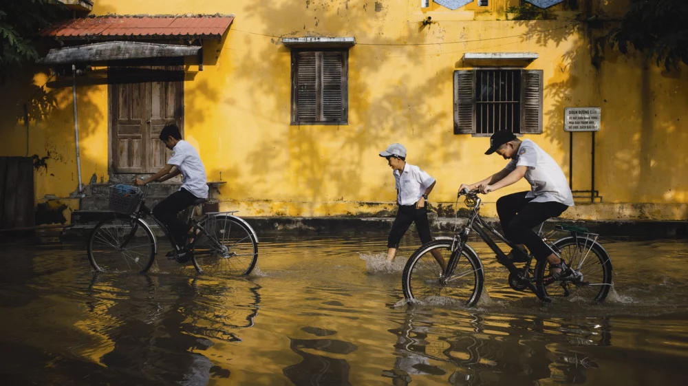 Children biking in a flooded area