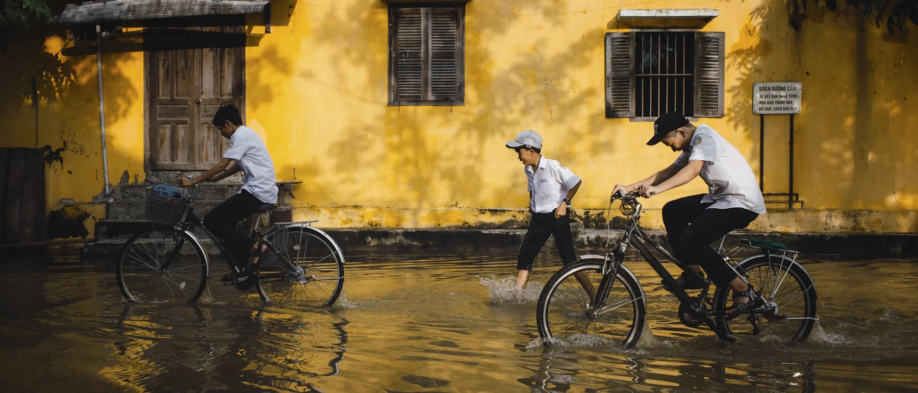 Children biking in a flooded area