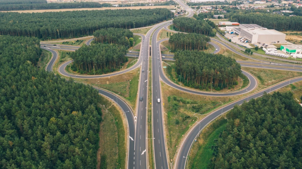 Aerial view of a highway interchange surrounded by dense forested areas