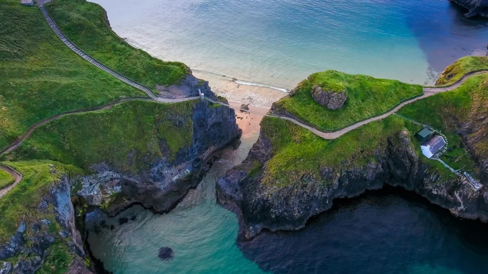Aerial image of coastline in Northern Ireland with a rope bridge connecting two pieces of headland over an inlet