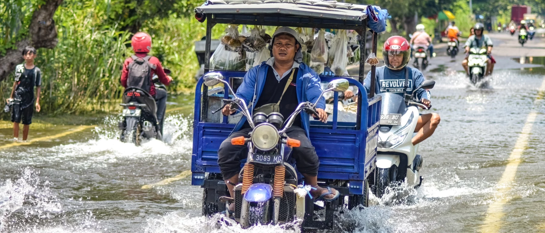 Several vehicles such as trucks, bicycles and cars were trapped by floodwater in Gresik Regency, Indonesia, 21 February 2024