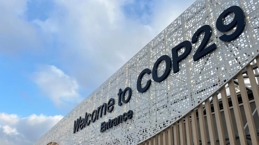 Entrance to COP29 conference with blue sky with white clouds in the background.