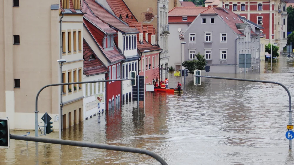 Flooded area with water submerging streets and surrounding buildings.