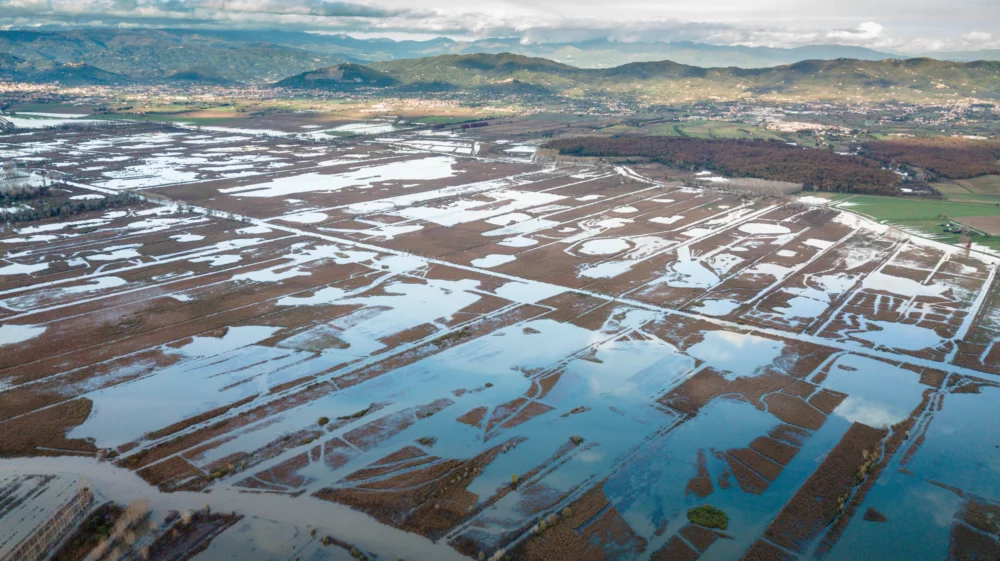 flooded fields from above with green mountains in the distance