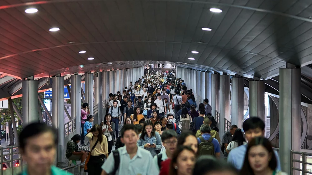 Crowd of people fill a pedestrian bridge in Bangkok, Thailand.