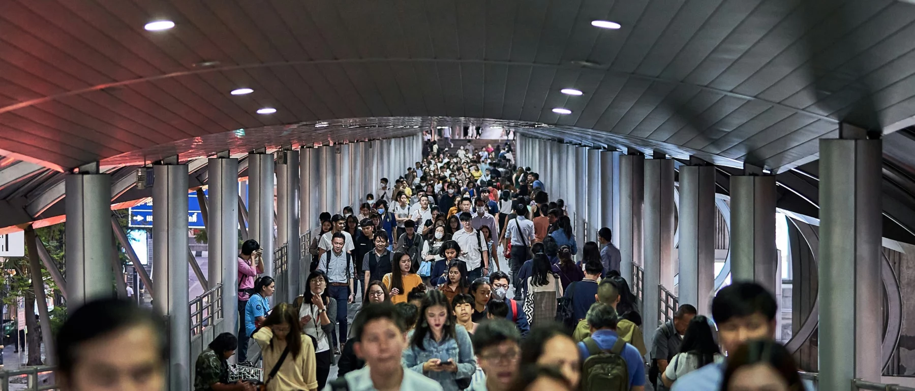 Crowd of people fill a pedestrian bridge in Bangkok, Thailand.