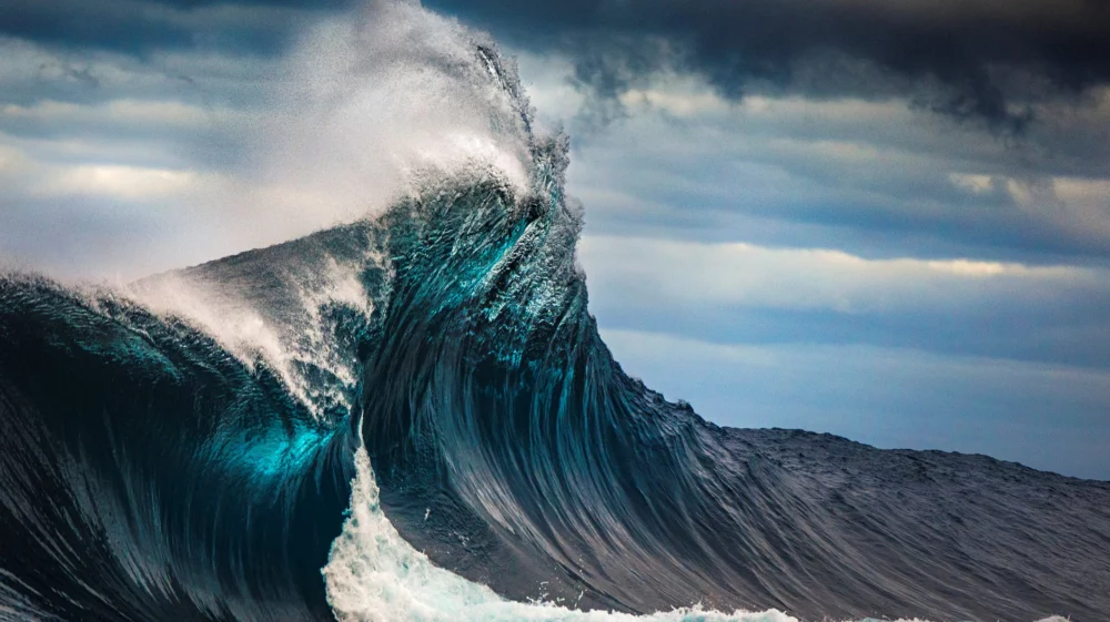 Powerful cross ocean wave breaking during a dark, stormy evening in Australia.