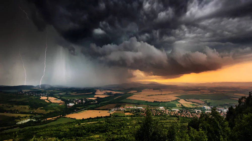A severe thunderstorm shelf cloud races across the countryside on a summer afternoon.